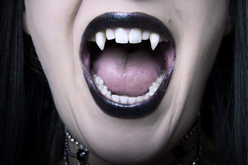 Close up aberto da boca da mulher do vampiro fotografia de stock royalty free Close up aberto da boca da mulher do vampiro fotografia de stock royalty free