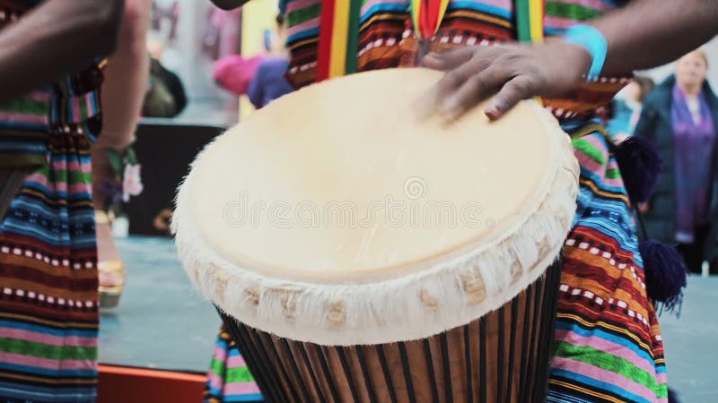 Close-up African s hands playing on djembe drum close up. Musician beats rhythm on african drums. Black artists hit the