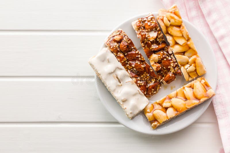 Close Up of Almond Brittle Bars with Caramelized Coating on Plate on White Table. Top View Stock