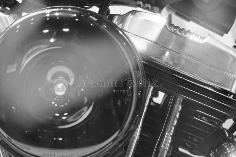 Close up of American heavy vintage motorcycle of a famous brand on showcase, power v twin engine elements, part close-up, motorbike with shiny chrome detail in monochrome, black and white backgrounds