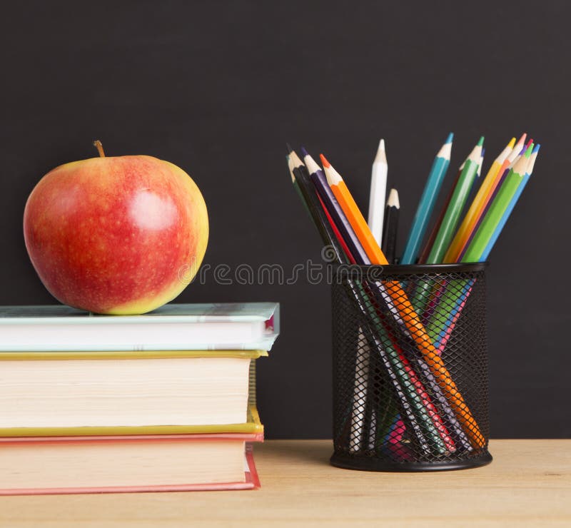 Close up of apple, books and pencils for kids lessons