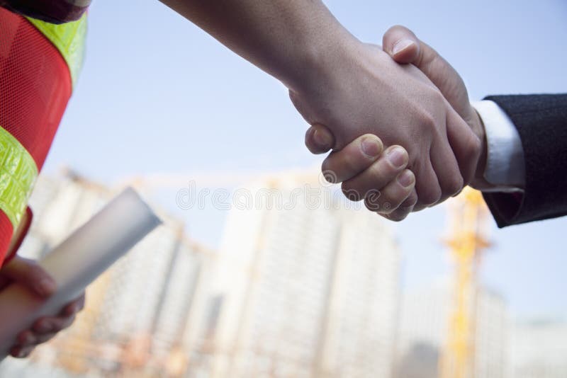 Close up of architect and building contractor shaking hands stock image Close up of architect and building contractor shaking hands stock image