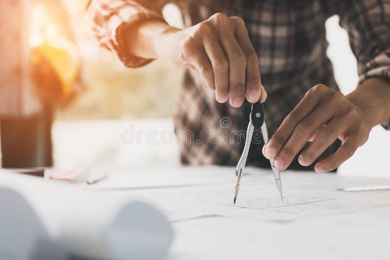Close up of an architect`s hands using a drawing compass on a bl stock image