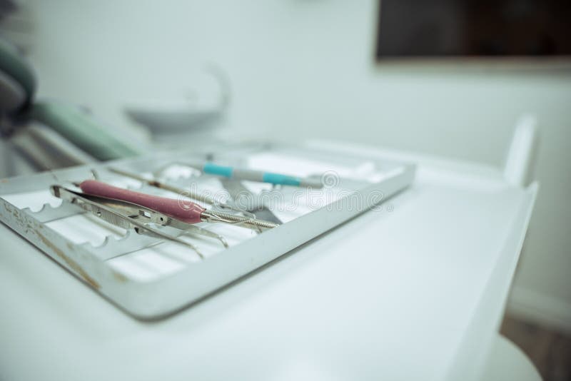 Close Up of Array of Dental Tool in Tray Next To Client Stock Image