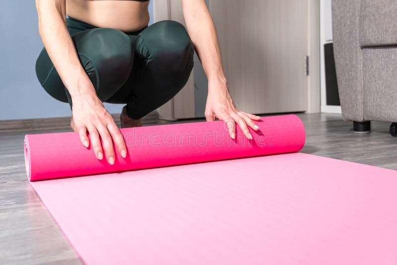 Close-up of Attractive Young Woman Folding Yoga or Fitness Mat after ...