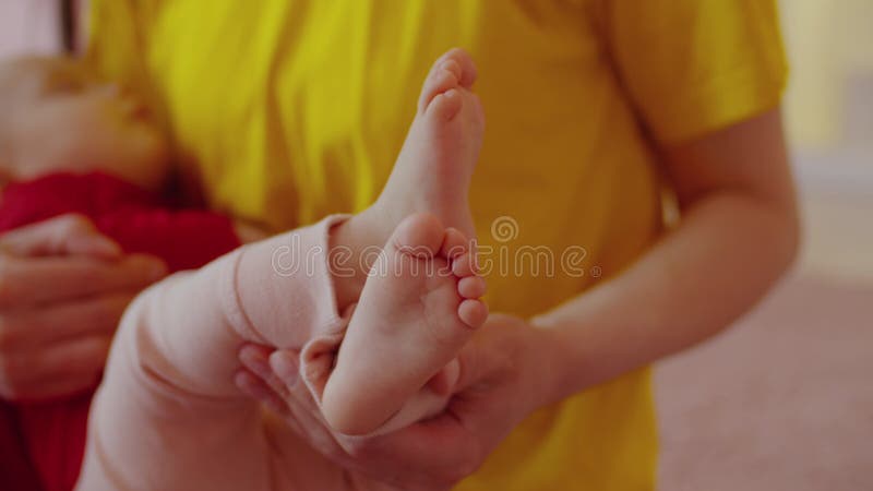 Close-up of barefoot tiny infant baby feet in mothers hand