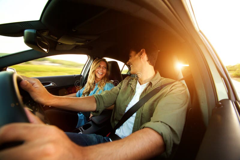 Close up beautiful couple laughing in car on road trip