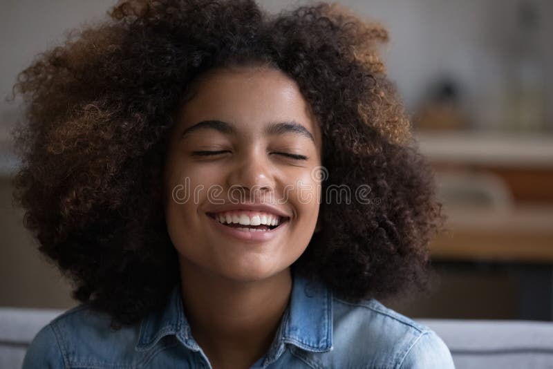 Beautiful African teenage girl closing eyes deep in pleasant thoughts