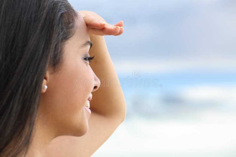 Close up of a beautiful woman looking at the horizon with a hand in forehead stock image Close up of a beautiful woman looking at the horizon with a hand in forehead stock image