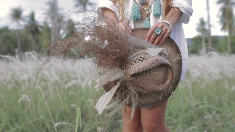 Close up of beautiful young stylish woman hands holding hat outdoors at sunset stock footage