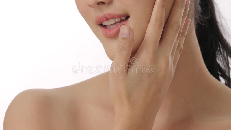 Close up portrait of beautiful young asian woman touching face and healthy skin in slow motion skincare concept.