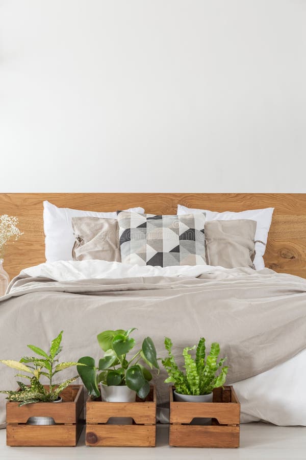 Close-up of a bed with sheets and pillows with boxes and plants stock photography