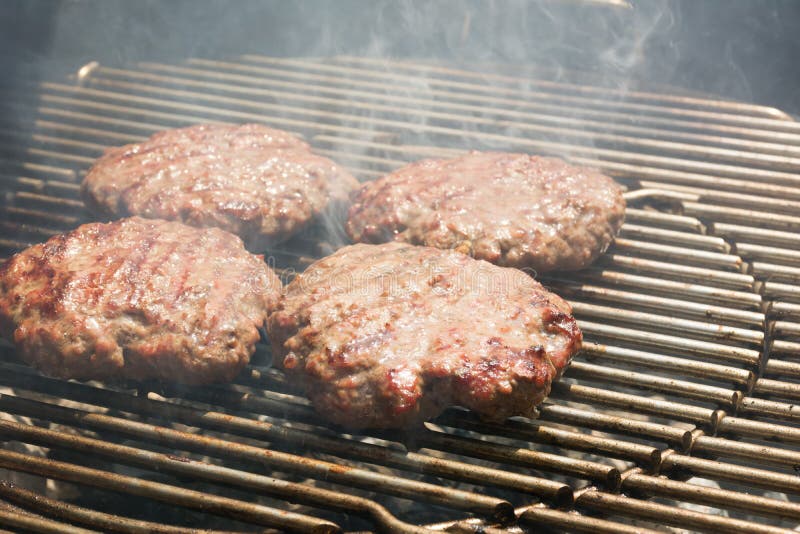 Close Up of Beef Hamburger Cooking on a Charcoal Grill Stock Photo