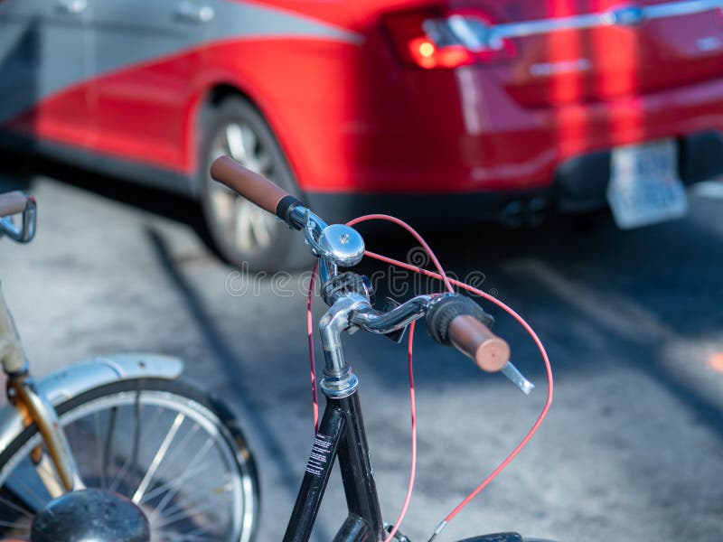 Close Up of Bike Handlebars and Bell Parked on Street Stock Photo