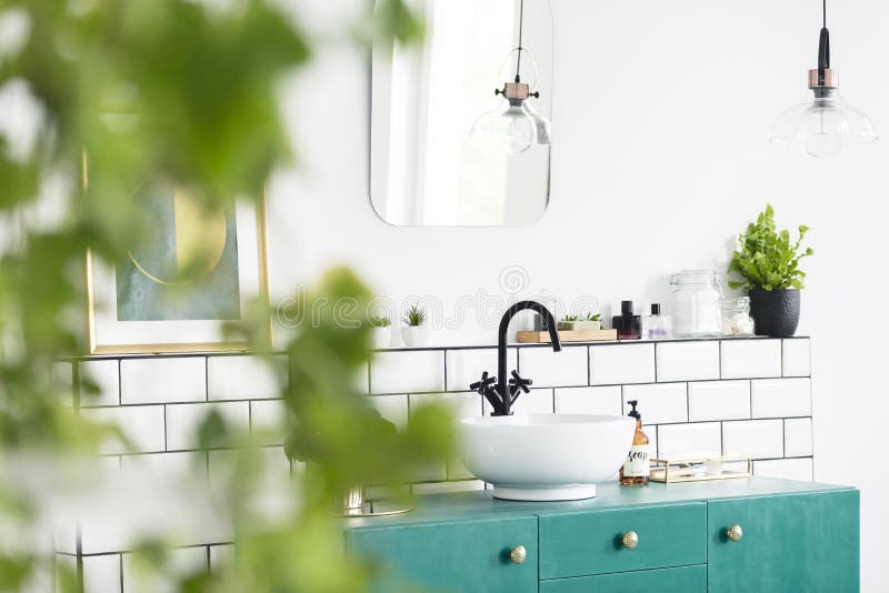 Close-up of blurred leaves with a sink, green cupboard and mirror in the background in the bathroom interior. Real photo stock photos Close-up of blurred leaves with a sink, green cupboard and mirror in the background in the bathroom interior. Real photo stock photos