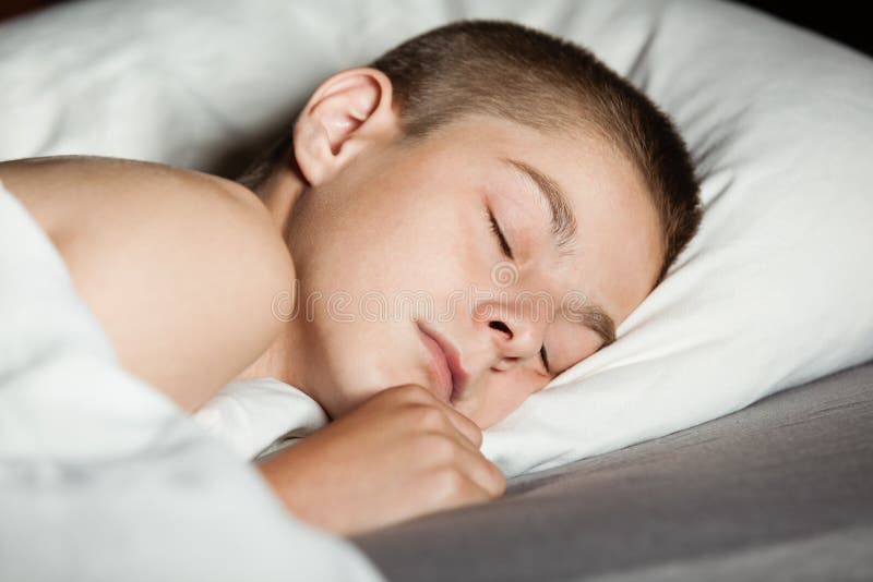 Close up on boy asleep in bed