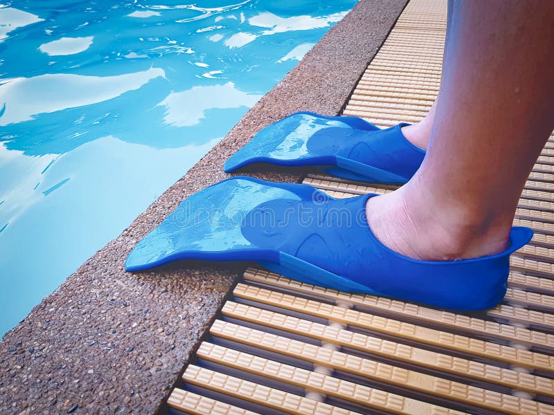 Boy Wearing Blue Swim Fin Flippers by the Swimming Pool stock photo Boy Wearing Blue Swim Fin Flippers by the Swimming Pool stock photo