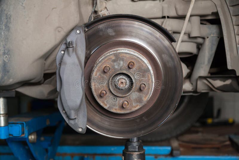 A close-up on brake system of a car with pads, discs, a caliper on a lift in a vehicle repair workshop. Auto service industry stock photos A close-up on brake system of a car with pads, discs, a caliper on a lift in a vehicle repair workshop. Auto service industry stock photos