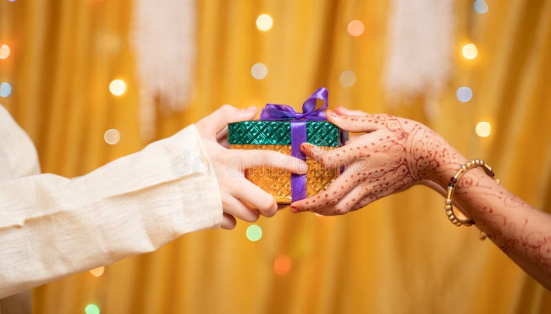Happy brother by closing eyes giving surprise gift to sister during raksha  bandhan festival celebration at home - concept of relationship bonding,  togetherness and family ceremony. Stock Photo | Adobe Stock