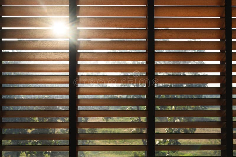 Close-up brown wooden blinds. lighting range control sunlight coming from a window. decoration interior. Modern jalousie