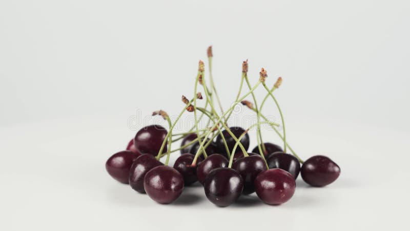 Close up of bunch of cherries on rotating table isolated on white background