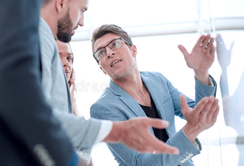 Close up.business team talking, standing near the flipchart royalty free stock image Close up.business team talking, standing near the flipchart royalty free stock image