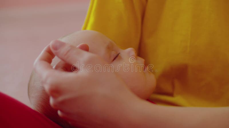 Close-up of calm adorable infant baby girl sleeping in mother hands