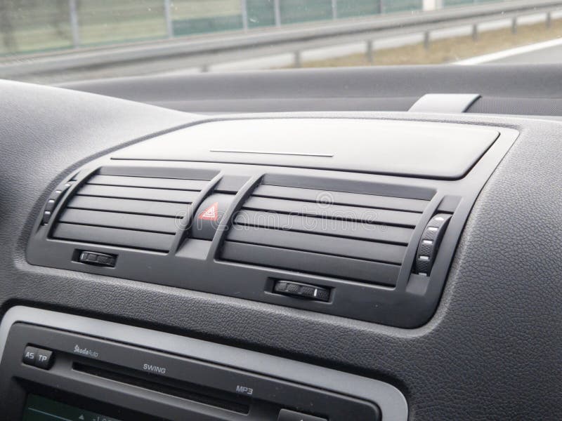 Close-up of a car's dashboard, featuring air vents and control buttons. Ideal for automotive design or technology themes stock photography