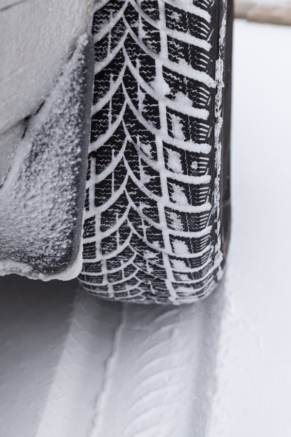 Close Up of Car Tyre in Winter Covered with Snow. Winter Tyre in
