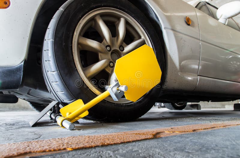 Close-up of Car wheel blocked by wheel lock because illegal parking violation