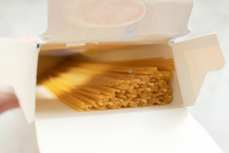 Close-up carton box with uncooked spaghetti. Ingredient for pasta. Food in packages stock photo Close-up carton box with uncooked spaghetti. Ingredient for pasta. Food in packages stock photo