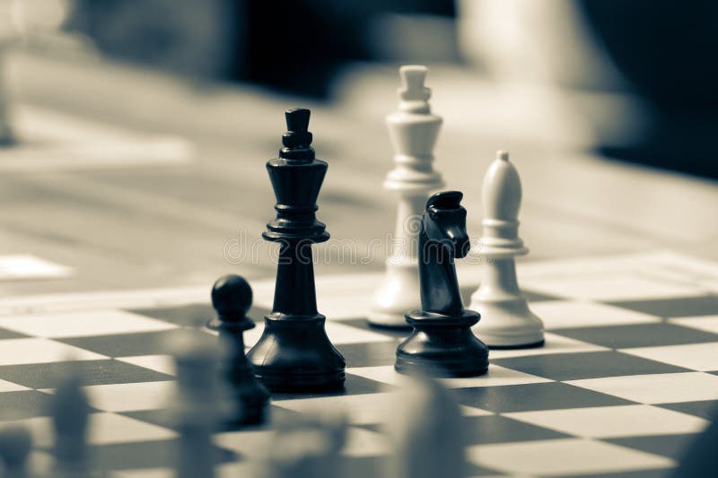 Close-up of white chess king and pawns on chessboard, strategy and leadership concept in soft focus light. stock photo
