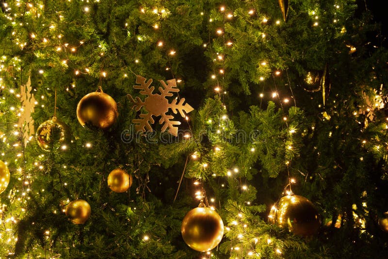 Close-up Christmas tree with decoration, light and gold ball at night