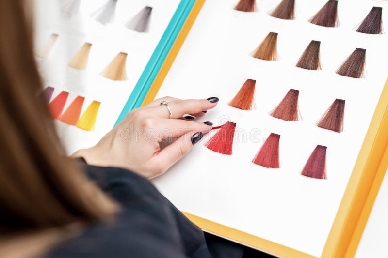Close up of client`s hand choosing color from hair samples in salon stock images Close up of client`s hand choosing color from hair samples in salon stock images