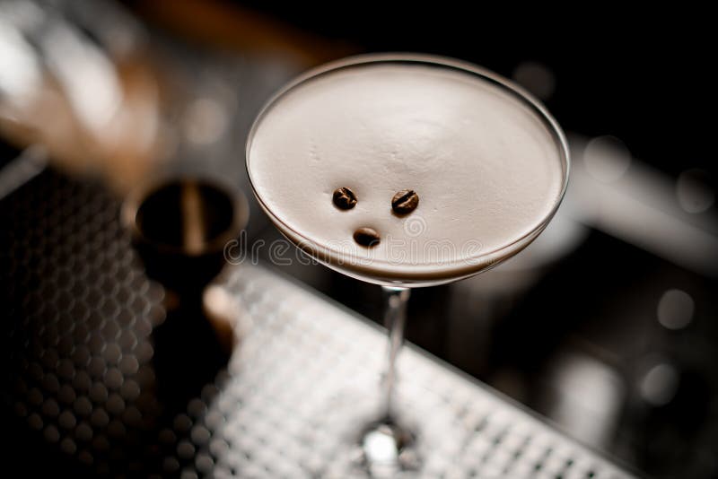 close-up on coffee beans which decorated glass with espresso martini cocktail