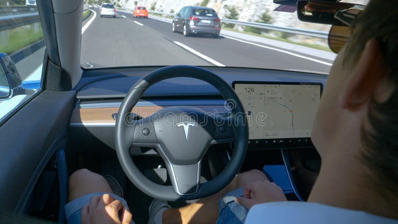 CLOSE UP: Commuter drives down the motorway in a high-tech self-steering vehicle royalty free stock photography