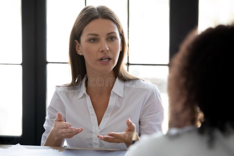 Close up confident serious businesswoman talking with business partner.