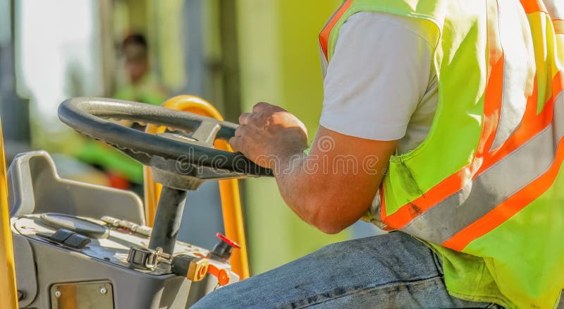 A close-up of a construction worker's arms skillfully operating heavy construction machinery royalty free stock photo