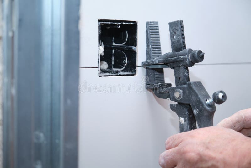 Close up of a constructor worker hand adjusting the separation between tiles. royalty free stock photos