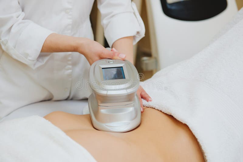 Close Up Of Cosmetologist Doing Massage With Special Apparatus On Female Belly Stock Image