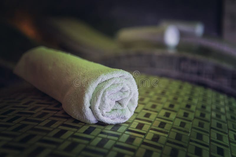 A close up of a cotton rolled bath towel on the wooden bedstone in a luxury spa. Clean and fresh individual towls are carefully stock image A close up of a cotton rolled bath towel on the wooden bedstone in a luxury spa. Clean and fresh individual towls are carefully stock image
