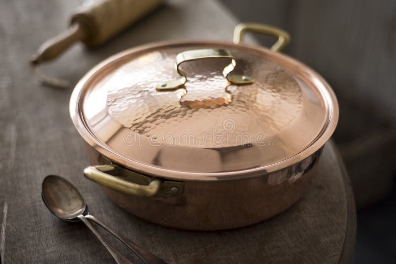 Close Up of Covered Copper Pot on Wooden Counter