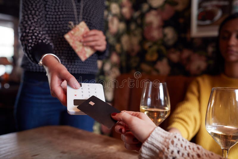 Close Up Of Customer Paying In Hotel Restaurant Using Contactless Card Reader stock image Close Up Of Customer Paying In Hotel Restaurant Using Contactless Card Reader stock image