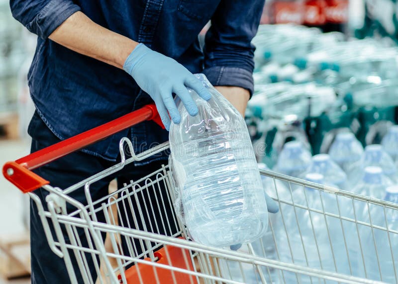 close up. customer in a protective mask choosing bottled water.