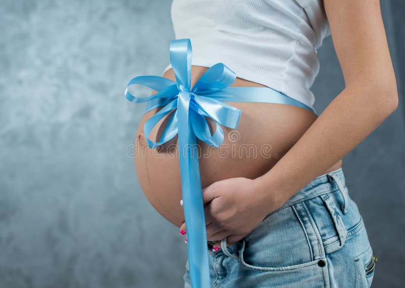 Close Up Of A Cute Pregnant Belly Tummy And Blue Ribbon ...
