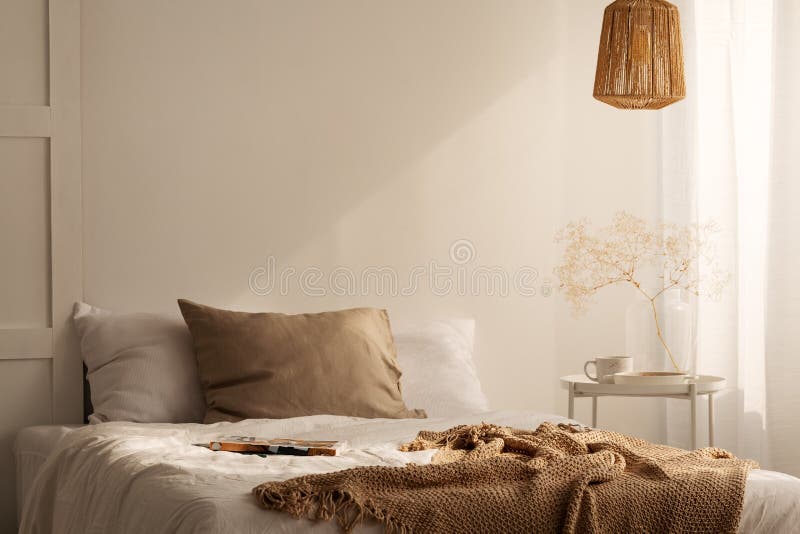 Close up da cama com cobertura bege e o descanso de linho no interior mínimo do quarto, foto real