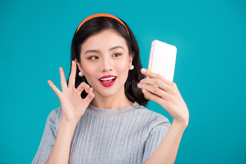 Close-up da menina asiática de sorriso do pinup bonito que toma a foto do selfie fotos de stock Close-up da menina asiática de sorriso do pinup bonito que toma a foto do selfie fotos de stock