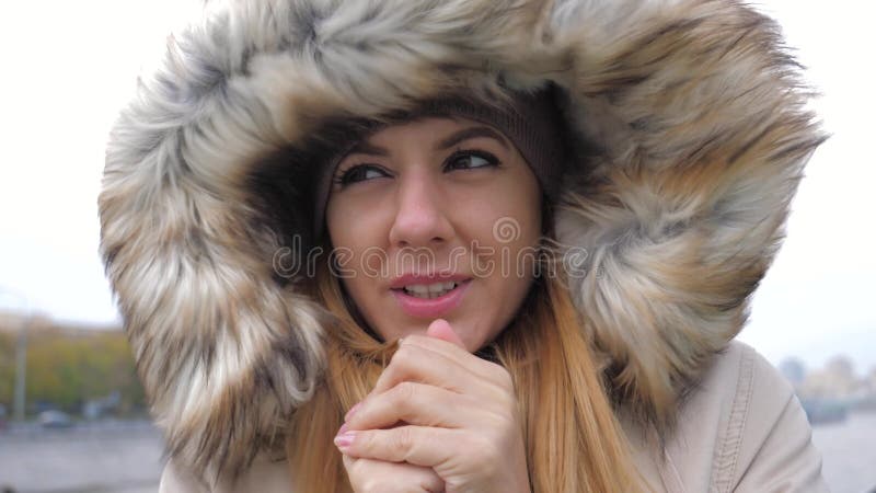 Close up da mulher em um revestimento com o vento frio forte de Hood She Closed From The