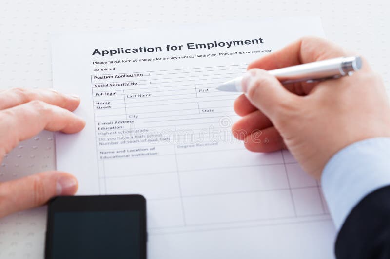 Close-up da mão que guarda Pen Over Employment Application