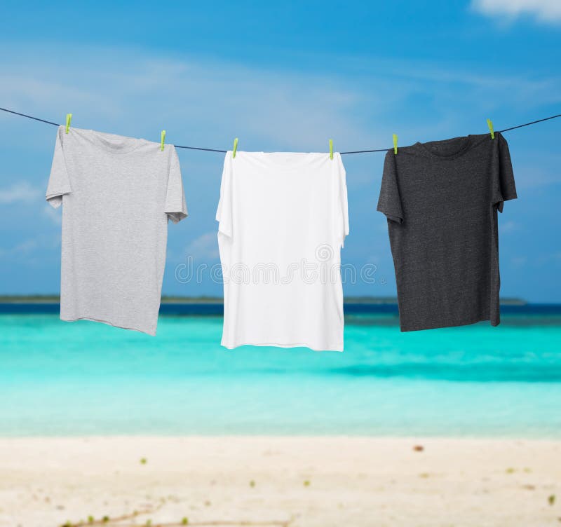 Close up of a dark grey, white and grey t-shirts on the rope.